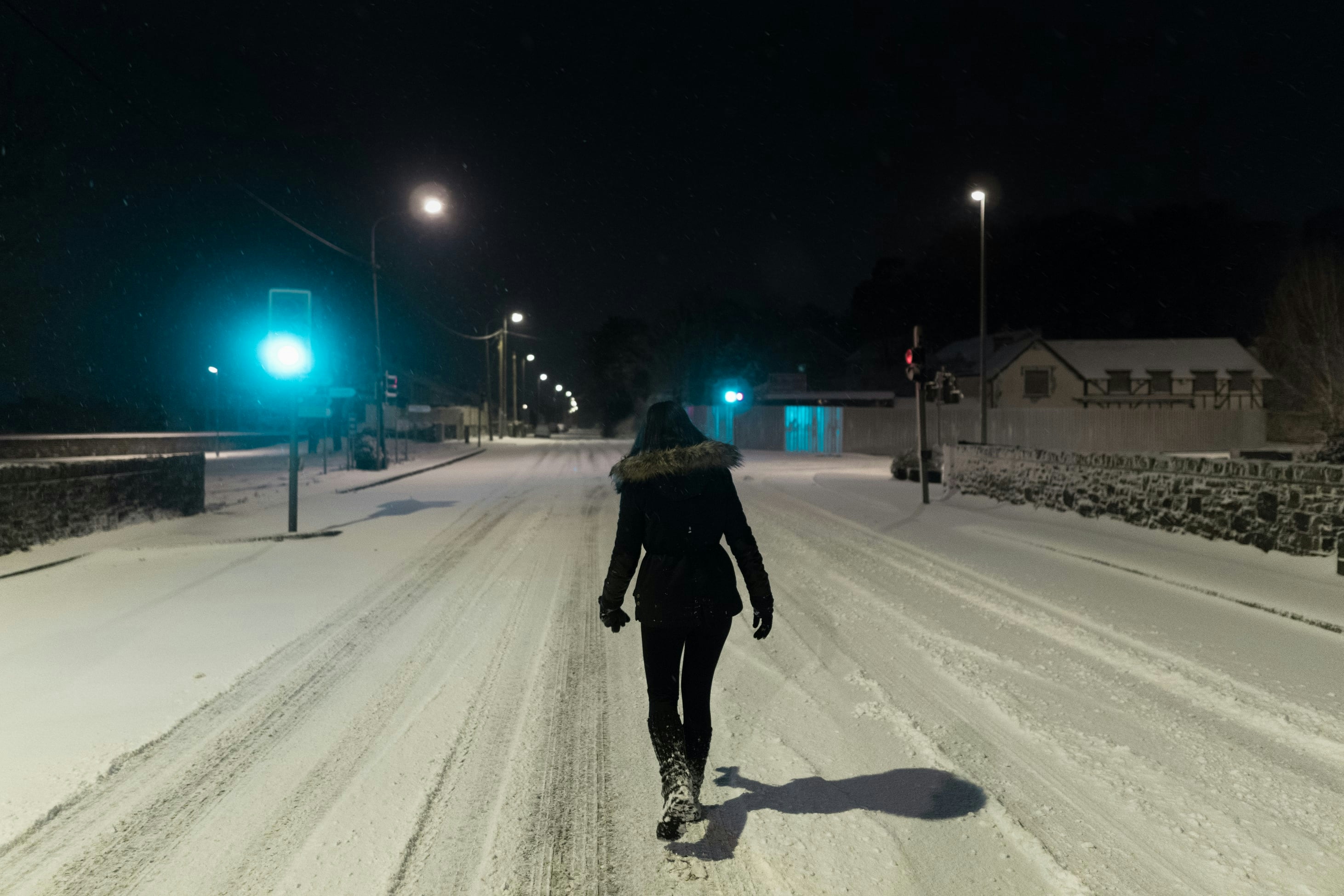 Laura walking on snow-covered street at midnight